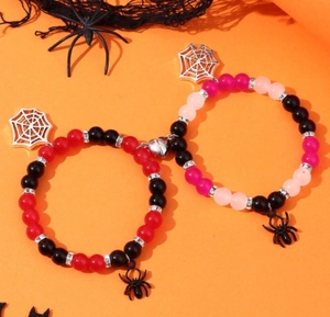 Close-up of Halloween magnetic couple bracelets with spider charms and red black beads