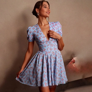 Détail d'une robe fleurie bleue avec col en V et manches bouffantes sur un mannequin