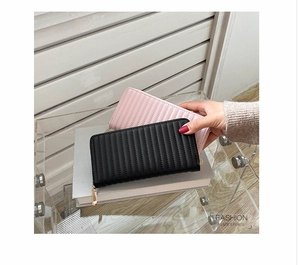 Close-up of black and pink quilted PU leather purses with golden zipper detail