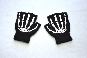 Detail of black fingerless knit gloves featuring white skeleton hand bone prints for teens