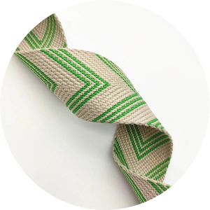Detail of wide beige and green herringbone pattern fabric strap for shoulder bags