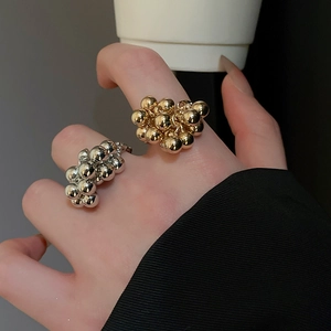 Macro shot of silver and gold stacked bead rings on fingers for a minimalist luxury look