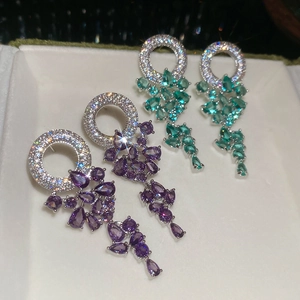 Détail de boucles d'oreilles en argent avec zircons violets et verts en forme de goutte