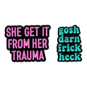 Enamel brooch set with text She Get It From Her Trauma and gosh darn frick heck quotes
