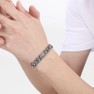 Close-up of vintage engraved silver curb chain bracelet for men with oxidized finish