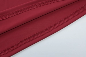 Détail macro du tissu en jersey rouge avec couture robuste à double aiguille sur l'ourlet