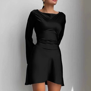 Détail d'une robe courte en satin noir avec manches longues et taille ceinturée