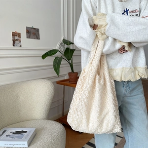Detail of floral lace embroidery on creamy-white large tote bag in French style setting