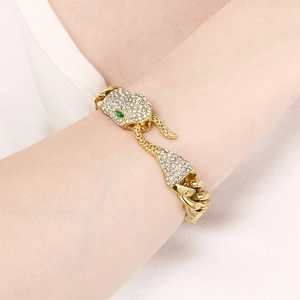 Detailed view of gold plated cuban link bracelet with sparkling paved stone snake head