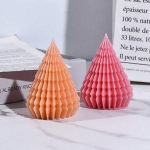 Detail of cone-shaped candles with wavy geometric texture in soft orange and pink