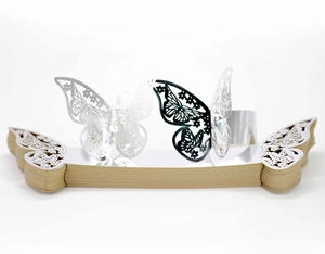 Detailed close-up of laser-cut butterfly napkin rings in silver and black paper