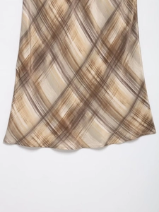 Detailansicht des braun-beigen Plaid-Midirucks mit künstlerischem Pinselstrich-Saummuster