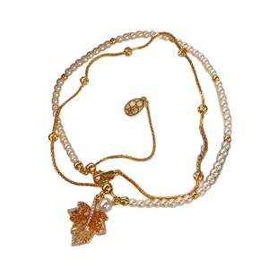 Gold-plated double-layer necklace with maple leaf pendant and pearls on white background