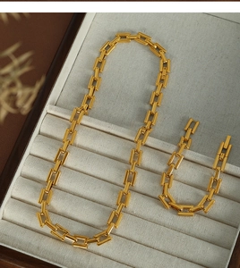 Detailed macro view of 18K gold-plated rectangle link chain necklace and bracelet set