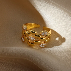 Close-up of gold beaded ring with sparkling clear zircon accents on champagne silk fabric