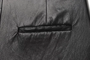 Détail de la poche horizontale et de la texture cuir sur la jupe-short en similicuir noir