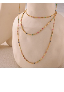 Detail of layered gold titanium necklace featuring vibrant colorful beads on long chains