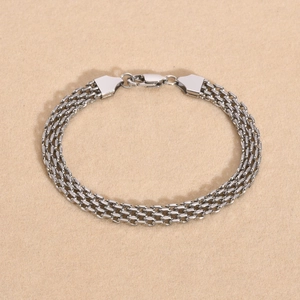 Macro shot of silver woven mesh multi-layer bracelet with secure lobster clasp closure