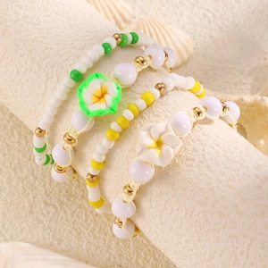 Set di quattro braccialetti di perline a tema spiaggia con fiori e ciondoli a stella marina