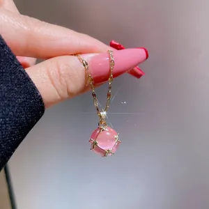 Makroaufnahme einer vergoldeten Titan-Halskette mit einem rosa Katzenaugenstein-Anhänger