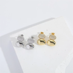 Detailed close-up of gold and silver layered drop earrings with micro-pave zircons and polish
