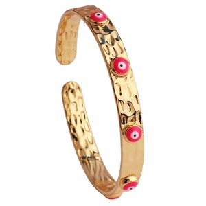 Dettaglio del bracciale rigido placcato oro 18K con occhi in smalto rosa e trama martellata