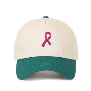 Detailansicht der rosa Schleifenstickerei auf der cremefarbenen Trucker-Mütze