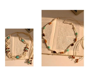 Détail d'une chaîne de taille bohème avec perles turquoise et bois sur livres anciens