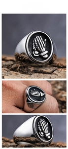Macro detail of vintage stainless steel punk ring with skull praying hands relief
