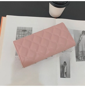 Pink quilted leather wallet displayed on an open magazine with a modern lifestyle aesthetic