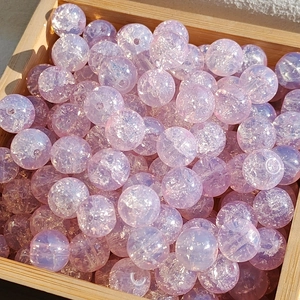 Macro detail of 10mm iridescent purple and pink cracked glass beads for DIY jewelry