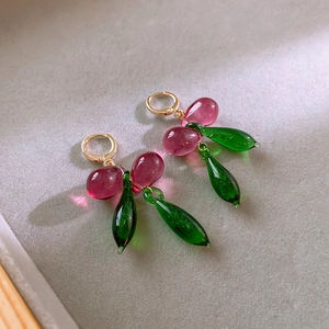 Detail shot of cherry-style drop earrings with purple and green glass beads