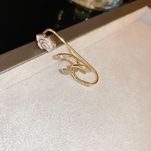 Detailed macro view of a gold brooch with pink rose decoration and crystal inlaid Logo