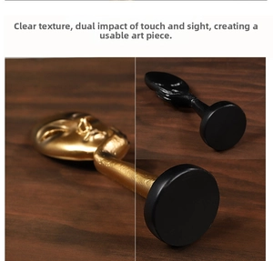 Detailed close-up of modern abstract resin face statues in matte black and gold finish