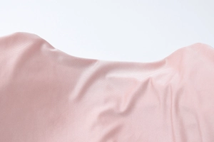 Detailed macro view of the smooth pink satin fabric showing fine texture and silk luster