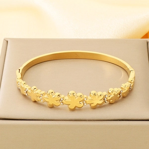 Detail eines 18K vergoldeten Armreifs mit floralen Reliefmustern und Zirkonia-Steinen