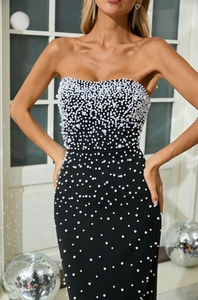 Detailed view of luxury black tube dress featuring 3D white pearls for party attire