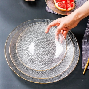 Detail shot of textured glass plates with gold rim stacking on a table