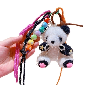 Porte-clés panda en peluche avec breloques étoile et perle sur fond blanc épuré