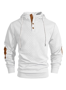 Gros plan sur le tissu gaufré avec empiècements marrons aux coudes sur le sweat blanc