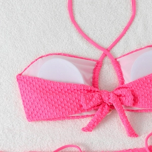 Detail of neon pink bikini top with honeycomb texture and removable round padding
