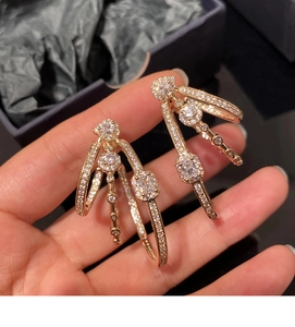 Close-up of gold layered oval hoop earrings with sparkling micro-paved cubic zirconia