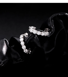 Gros plan de boucles d'oreilles en C en argent avec moissanite sur cuir noir élégant