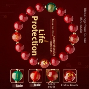 Detail of red beaded bracelet with green jade bead and golden Chinese zodiac carvings