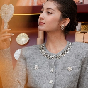 Detail of grey knit cardigan with crystal floral buttons and sparkling neckline decor