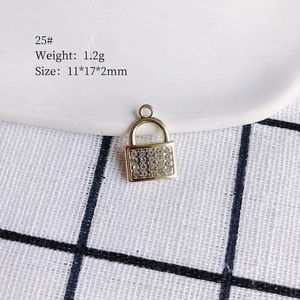 Detailed macro view of gold-plated padlock pendant with sparkling zircon inlays for DIY jewelry