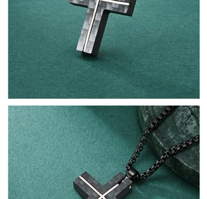 Close-up of black carbon fiber cross pendant with gold inlay and black metal chain