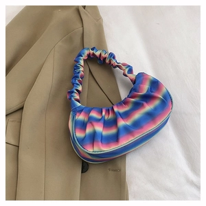 Macro view of gradient rainbow pleated shoulder bag on white fabric background