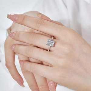 Close-up of radiant square-cut high carbon diamond ring with pavé band on finger