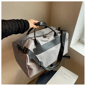 Detail of silver gym bag featuring premium nylon texture and sturdy black carry handles